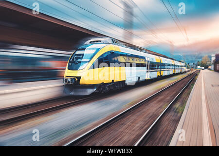 Train jaune à grande vitesse en mouvement à la gare Banque D'Images