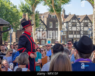 Londres, Angleterre - 5 août 2018 : un gardien de Yeomen à l'intérieur de la Tour de Londres sur une chaude journée d'été une conférence à un groupe. Historique Ce château normand Banque D'Images