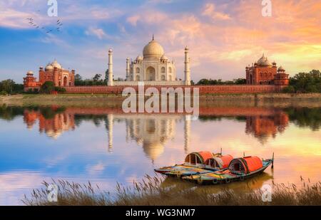 Taj Mahal Agra sur les bords de la rivière Yamuna au coucher du soleil avec moody sky et afficher de bateaux en bois utilisé pour les touristes sur la rivière ride Banque D'Images