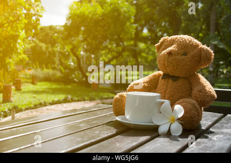 Ours en peluche avec une tasse de café sur fond blanc