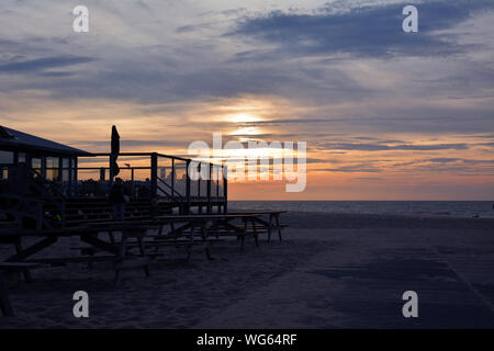 Silhouette d'une terrasse extérieure de beach pavilion 'Paal 17' avec le coucher du soleil sur la mer en arrière-plan de scène sur l'île de Texel en Hollande du Nord Banque D'Images
