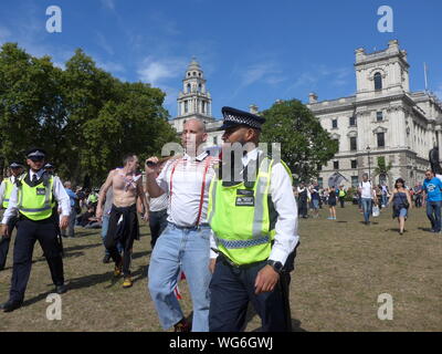 Tommy Robinson partisans mars à College Green avec une escorte de police comme des milliers protester à Whitehall le 1er septembre 2019. Banque D'Images