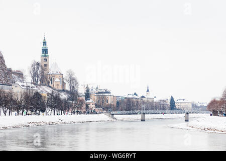 La vue le long de la Salzach, à Salzbourg, Autriche en regardant vers le pont "ullner Steg' et l'église paroissiale Mulln, une église catholique romaine. Banque D'Images