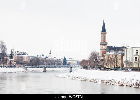 Une vue du milieu de l'hiver le long de la Salzach, à Salzbourg, Autriche vers la paroisse protestante Christ Church de Salzbourg et de l''Mullner Steg' Bridge. Banque D'Images