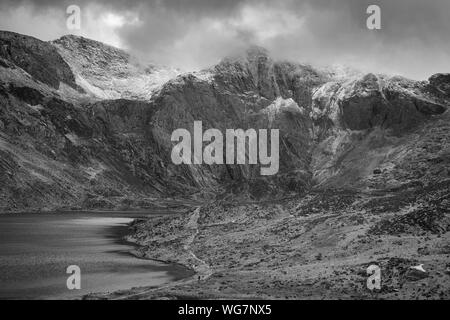 Superbe paysage d'hiver spectaculaire image de Llyn Idwal et sommets de montagnes de Snowdonia en Glyders en noir et blanc Banque D'Images