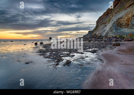 Beau lever de soleil sur l'Saltwick Bay sur la côte du Yorkshire, près de Whitby Banque D'Images