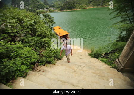 (190901) -- LINGYUN, 1 septembre 2019 (Xinhua) -- Ketuan Lao se dirige vers son domicile après son amarrage bateau-Haokun au Village de Lingyun County, Chine du Sud, région autonome Zhuang du Guangxi, 30 août 2019. Ketuan Lao, 40 ans, vit dans le village montagneux de Haokun, lieu de transport extrêmement pauvres et maigres ressources foncières gravement entravé le développement local et amené les gens ici au piège de la pauvreté. La famille d'ajo est parmi les ménages pauvres qui vivent ici. En 2016, AJO a cependant jamais rêvé que sa famille ne pouvait s'extraire de la pauvreté grâce à des autorités locales Banque D'Images