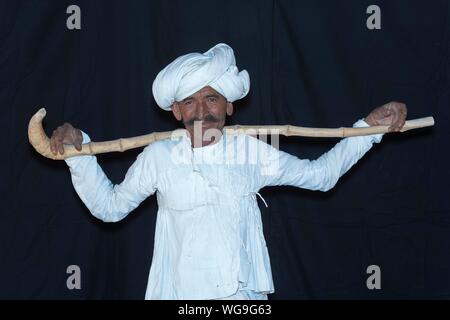 Rabari Homme portant des vêtements blancs avec turban et holding bâton de marche, Grand Rann de Kutch, Gujarat, Inde Banque D'Images