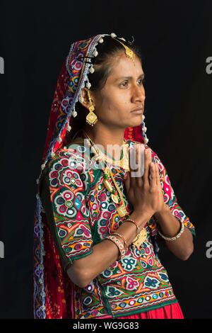 Woman in traditional Ahir vêtements colorés prier, Grand Rann de Kutch, Gujarat, Inde Banque D'Images