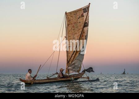 Au lever du soleil, les pêcheurs en pirogue traditionnelle outrigger bateau sur l'Océan Indien, Madagascar Banque D'Images