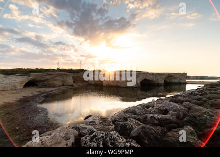 Tiré de la lever de soleil derrière les rochers à Cirica Bay au lever du soleil. Cirica est une belle nature balnéaire dans le sud de la Sicile, Italie Banque D'Images