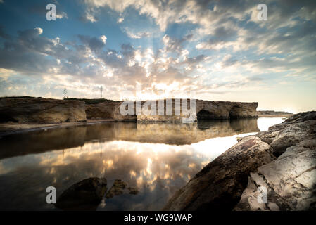 Tiré de la lever de soleil derrière les rochers à Cirica Bay au lever du soleil. Cirica est une belle nature balnéaire dans le sud de la Sicile, Italie Banque D'Images