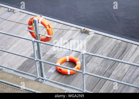 Bague orange bouée ponton sur l'eau de mer pour la sécurité au port de plaisance Banque D'Images