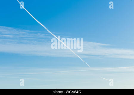 Les avions laissant trace diagonale sur un ciel bleu Banque D'Images