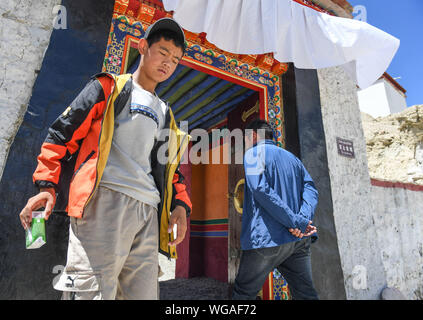 (190901) -- 1 septembre, NGARI, 2019 (Xinhua) -- Basang Cering (R) passe par l'entrée de l'Guge Kingdom reliques en Zanda Comté de la préfecture de Ngari, sud-ouest de la Chine, région autonome du Tibet, le 30 juillet 2019. Chaque année, environ 100 000 personnes visitent les ruines d'un ancien royaume mystérieux dans l'ouest du Tibet. La plupart sont des touristes qui passent par brièvement, mais pas Basang Cering. L'homme de 30 ans, a été de maintenir le Guge Kingdom reliques depuis 2013 dans la région de Zanda County, préfecture Ngari, sud-ouest de la Chine, région autonome du Tibet. Il a étudié la peinture traditionnelle tibétaine une technique appelée t Banque D'Images