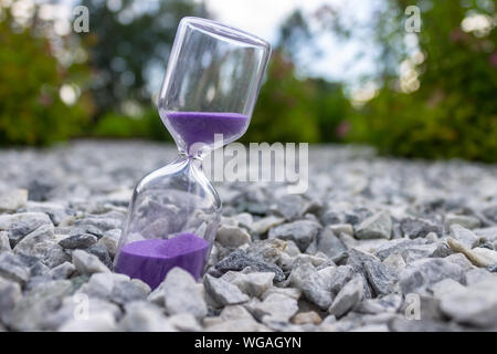 Hourglass close-up sur la rue dans le parc comme un symbole de l'temps qui passe Banque D'Images