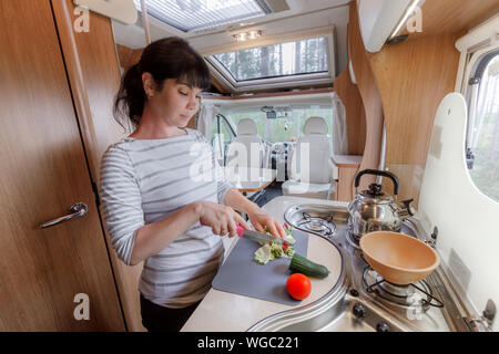 La cuisine femme dans le camping-car, Camping RV de l'intérieur. Vacances famille vacances, voyages voyage en camping-car, caravane location de vacances. Banque D'Images