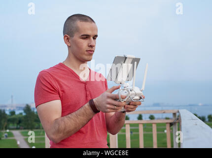 Jeune homme l'exploitation d'une console de commande à distance de drones. Banque D'Images