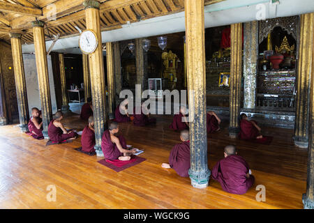 Inle, Myanmar - Avril 2019 : les moines novices birmane la lecture de livres dans le monastère Banque D'Images