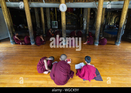 Inle, Myanmar - Avril 2019 : les moines novices birmane la lecture de livres dans le monastère Banque D'Images