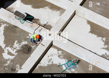 Les travailleurs en uniforme sable propre sur un site de construction, vue d'en haut. Banque D'Images