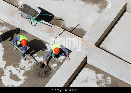 Les travailleurs en uniforme sable propre sur un site de construction, vue d'en haut. Banque D'Images