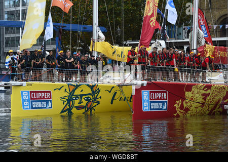 L'équipe de Punta del Este (à gauche) et l'équipe de Qingdao, les deux prenant part à la Clipper Round the World Race, attendez sur leurs bateaux à la cérémonie de départ à St Katharine Docks Marina, par la Tamise dans le centre de Londres, avant leur départ vers le bas de la rivière. Banque D'Images