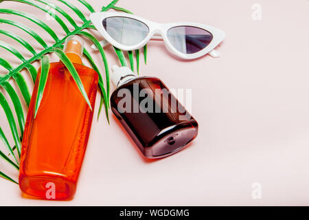 Sunblock sur bouteille carrée jaune lumineux et fond rose. Le concept de la station en mer, l'heure d'été. Haut de la vue, télévision lay, minimalisme, copy space Banque D'Images