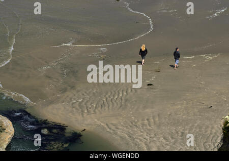 Vue sur la falaise de personnes marchant sur la plage, à l'Devils Punchbowl à Otter Creek, Oregon, près de Newport Banque D'Images