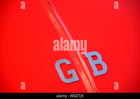 Close up detail d'un badge chrome GO sur une Austin Healey rouge classic car full frame Banque D'Images