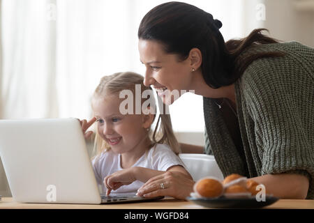 Mère-fille à l'écran du portable à passer du temps dans la cuisine Banque D'Images