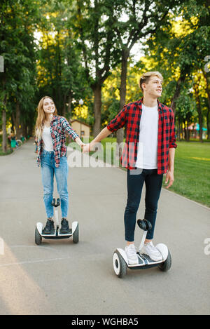 Jeune couple riding sur le gyroscope conseil en park Banque D'Images