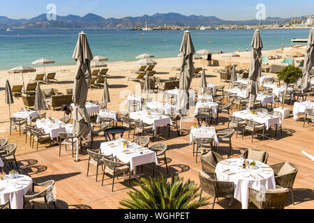 CANNES, FRANCE - Avril 2019 : salle à manger extérieure avec des tables fixées à un restaurant en bord de mer à Cannes. Banque D'Images