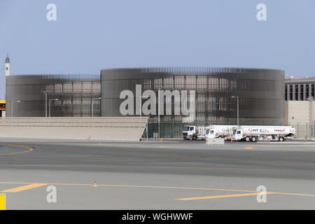 Doha, Qatar, Hamad Aéroport International, 2018-05-01 : d'énormes stockages pour le carburant aviation, décorées avec des grilles. Réservoir à essence camion garé près de Banque D'Images