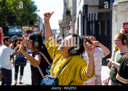 Femme avec casque chantant lors d'une Silent Disco Tour à Londres, Royaume-Uni Banque D'Images