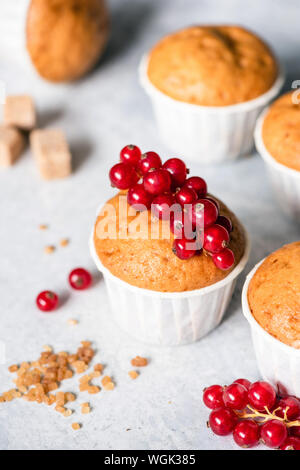 Des muffins en papier blanc tasses décorées avec des baies de groseille rouge. Muffins à la vanille Banque D'Images