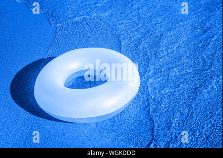 Bague en caoutchouc dans la mer. Filtre bleu Banque D'Images