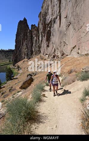 Jeune couple misère ascend Ridge Trail à Smith Rock State Park, Oregon sur une journée d'été sans nuages. Banque D'Images