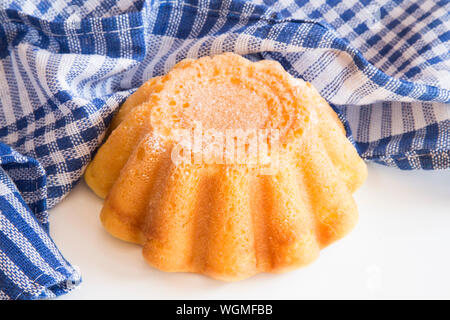 Gâteau bundt Mini avec un chiffon bleu sur fond blanc Banque D'Images