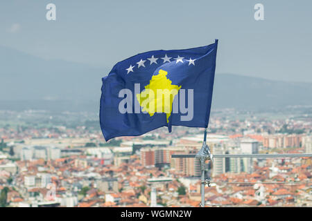 Waving Flag du Kosovo face ville floue Banque D'Images