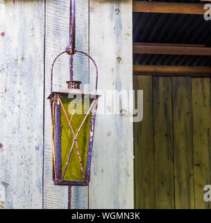 Vintage lanterne rouillée avec le verre teinté accrochée à un mur en bois, éclairage extérieur et décorations Banque D'Images