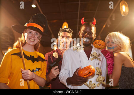 De la taille des profils des gens portant des costumes d'Halloween qui se présentent comme des sorcières et des pirates à l'appareil photo pendant la partie grimaçants, tourné avec flash Banque D'Images