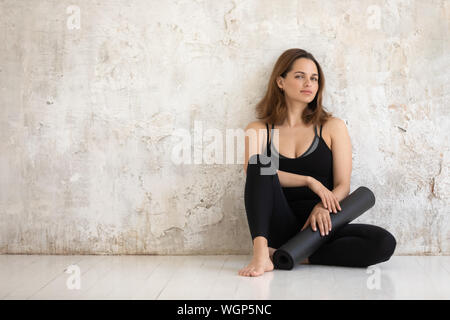 Magnifique Portrait woman black tapis de yoga, sitting on floor Banque D'Images