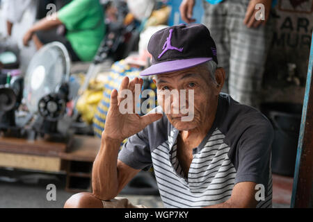 Un homme de son pays pose pour un portrait sur un trottoir à l'intérieur de la ville de Cebu, Philippines Banque D'Images