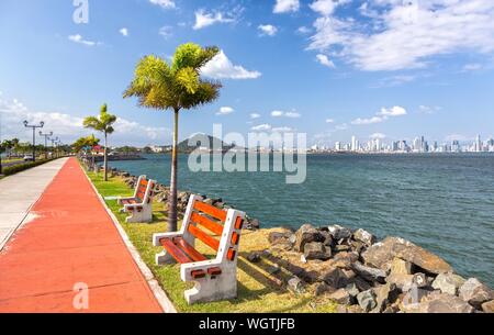 L'Amador Causeway Road, Panama Ville célèbre promenade en plein essor et une attraction touristique avec des bancs de parc, de palmiers et du centre-ville skyline sur horizon Banque D'Images