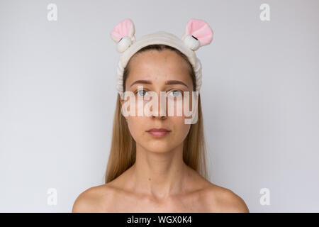 Portrait d'une jeune femme sur fond blanc. Soins de la peau et des soins spa à domicile ou salon de beauté. Concept de cosmétologie Banque D'Images