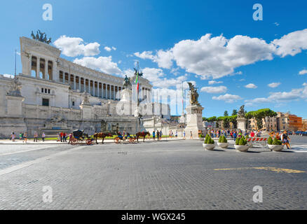 Le Monument à Victor Emmanuel II Rome Italie sur la Piazza Venezia sur une chaude journée d'été avec les chevaux et calèches pour voitures Banque D'Images