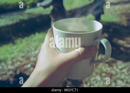 Le matin, une tasse de café en main, vintage la nuance de couleur. Banque D'Images