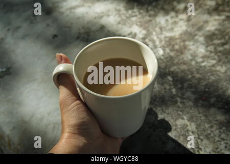 Le matin, une tasse de café en main, vintage la nuance de couleur. Banque D'Images