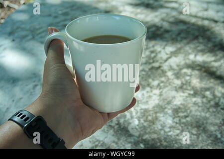 Le matin, une tasse de café en main, vintage la nuance de couleur. Banque D'Images